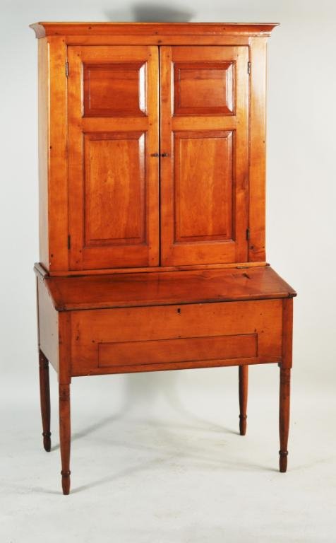 American Sheraton Country Maple Secretary: American Sheraton country maple secretary, with paneled upper doors, set on a base section with well and slant lid, raised on turned legs. Probably Connecticut, early 19th century. 69" high, 36 3/4" w