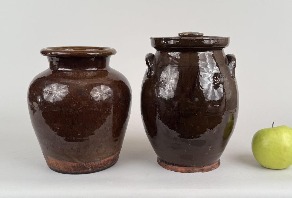 Two Redware Crocks: the smaller lidded. Larger: 9" high, 7" diameter. Chips to lid.