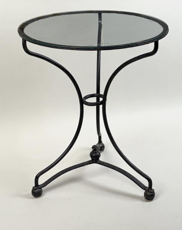 Wrought Iron Glass Top Round Occasional Table: with stylish triangular shaped and footed base. 28 1/2" high, 24" diameter. Some rust, oxidation and soiling. Property from the Estate of Bobbie Hainline Howrey.