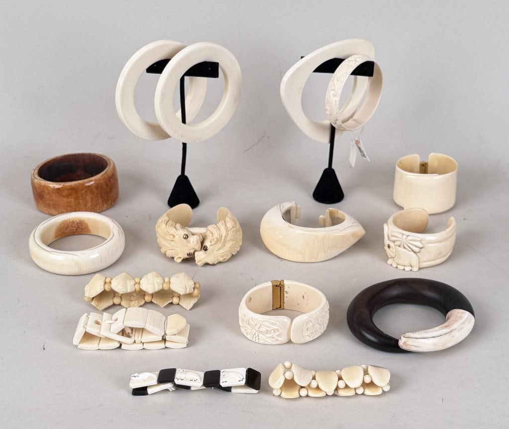 Group Carved Bone Bangles: including African, Lion, Chinese floral, Inuit themes. Largest: 3 7/8" high, 3 3/4" wide. interior approximately 2 3/8" diameter. Cracking, use wear. International clients are ineligible to bid on thi