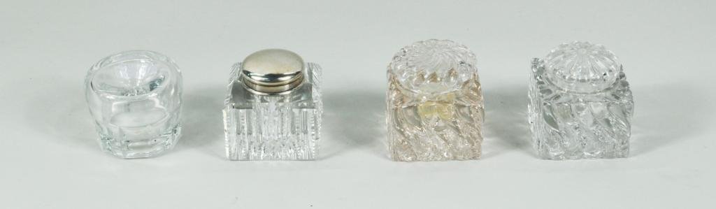 Group Four Glass Inkwells: Group of four glass inkwells, one with sterling silver lid, hallmark of Mauser Manufacturing Co., 19th/20th C. Largest: 3" high, 2 1/2" wide, 2 1/2" deep; smallest: 2 1/4" high, 2 3/4" diameter.