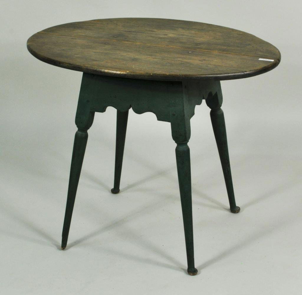 Queen Anne Style Oval Top Tea Table: Queen Anne style oval top tea table, in green paint with scrub top above scalloped apron, turned, tapering splayed legs terminating in pad feet. 25 1/2" high, 32" wide, 23 1/4" deep.