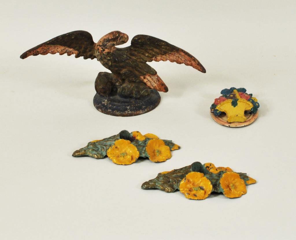 Four Polychromed Cast Iron Items, Iron Eagle: Four polychromed cast iron items, 20th C., comprising an eagle doorstop, basket knocker and floral candleholders. Smallest: 3 3/4" high, 2 3/4" wide, largest: 5" high, 10 1/2" wide.