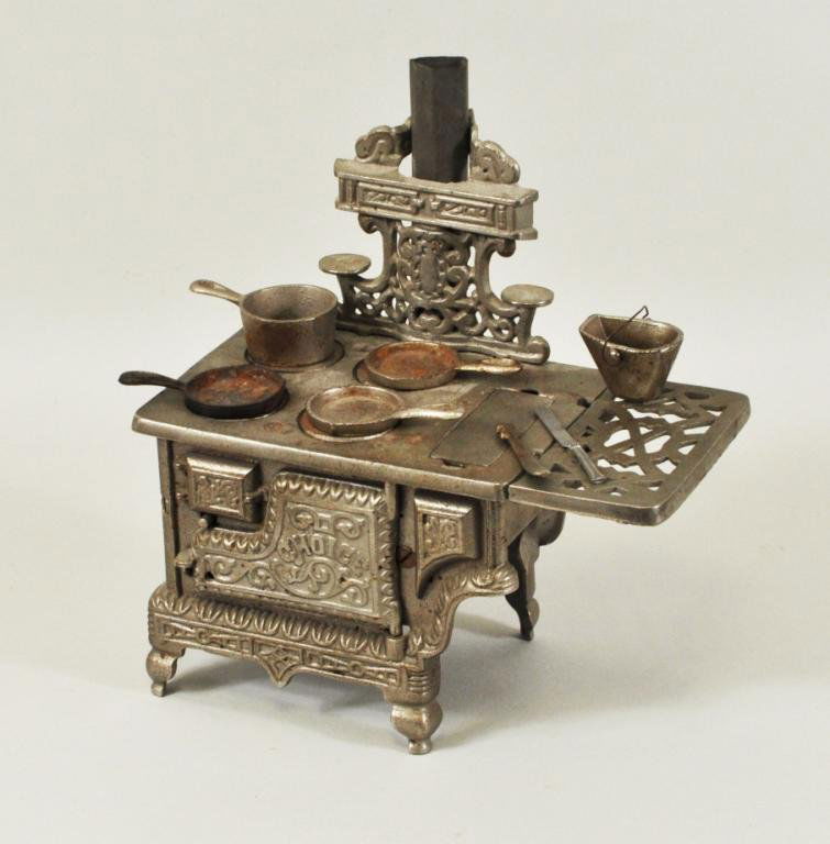 Child's Cast Iron Cook Stove: Child's cast iron "Choice" cook stove, 19th/20th C, with five pots and cover handle, stamped Pat. Pend. on back. 10" high, 9" wide. Condition: finish wear, rust.