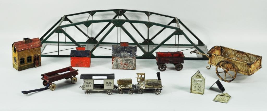 Group Eleven Metal Toy Items: Group eleven metal toy items, 19th/20th C., including a Champion Express wagon, a two wheeled cart, three railroad cars and a bridge and others. Largest: 6 1/4" high, 28" wide, 6" deep; smallest: 3 1/