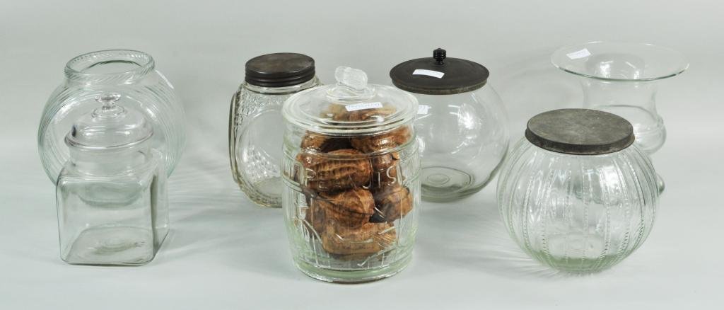 Group Seven Glass Containers: Group seven glass containers, 19th/20th C, including five store candy containers, a Planters peanut jar and an urn. Largest: 10 1/2" high, 7" wide; smallest: 8 3/4" high, 4 3/4" wide. Condition: rim c