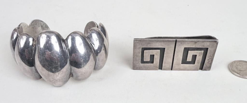 Mexican Sterling Money Clip & Cuff Bracelet: Greek key style money clip signed Emma, and Los Ballesteros modernist cuff bracelet. Money clip: 2 1/4" wide, 1" deep; cuff: 2" high, 1 1/2" wide, 1 1/2" deep. Gross weight: 3.070 OZT. Oxidation, age