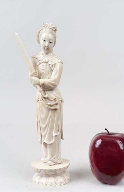 Signed Chinese Carved Bone Sculpture: either Mulan or Guanyin holding two swords; signed on bottom. 10 3/4" high, 2 1/2" wide, 2 5/8" deep. Cracks, small chip on bow. International clients are ineligible to bid on this item. It is for sal