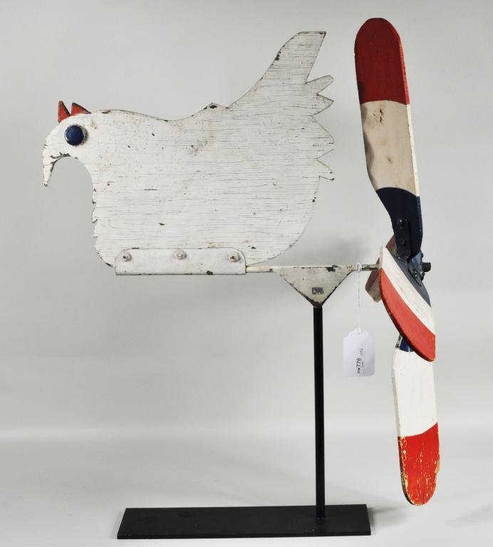 Folk Art Wood & Metal Hen Whirlygig: Folk art wood and metal hen whirlygig, early 20th C., hen in white paint with red comb and black bottlecap eyes, wind vane in red, white & blue on wrought iron display stand. 27" high, 21" long. Condi