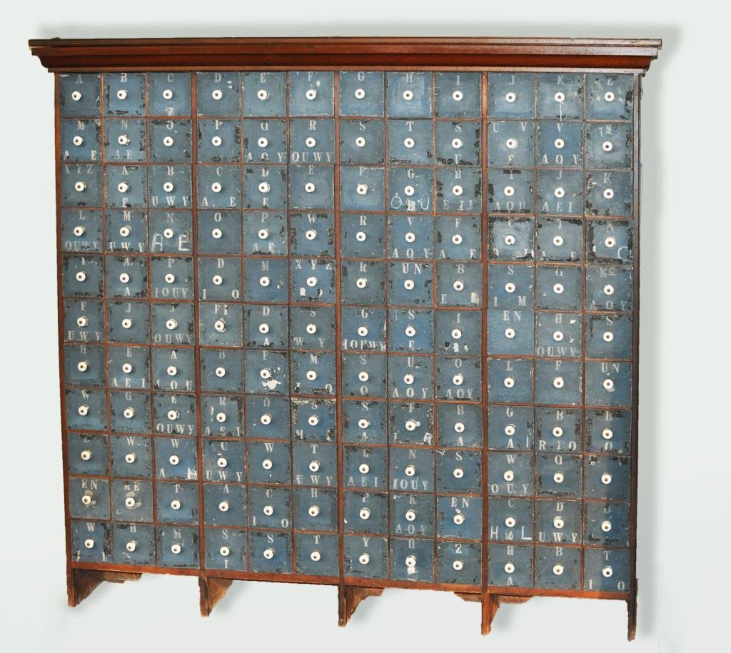 Poss. General Store Seed or Dye Packet Cabinet: Possibly a general store seed or dye packet cabinet, 19th/20th C, with blue painted alphabetically lettered scoop form tin drawers in large stained cabinet. 67" high, 69" wide, 13 1/2" deep. Condition