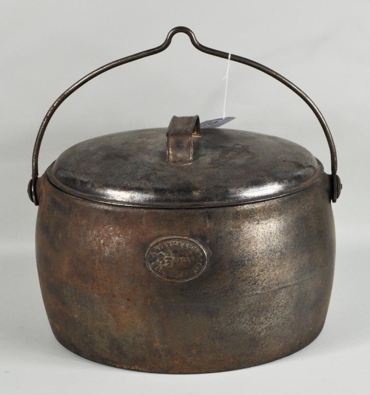 Kenrick & Sons Cast Iron Dutch Oven: Kenrick & Sons, West Bromwich 3 1/2 gallon cast iron dutch oven with tin lid, 19th/20th C, embossed label on body. 15" high, 15" wide. Condition: extensive use wear, finish wear, rust. Provenance: The
