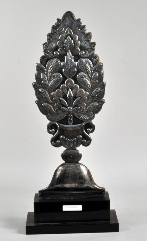 Prob. Spanish Colonial School, Silver Ornament: Probably Spanish Colonial school, 18th/19th C., silver repousse ornament of a foliate handled urn, with wood backing on display stand. Ornament: 17 1/4" high, 6 1/4" wide. Condition: dent to handle at