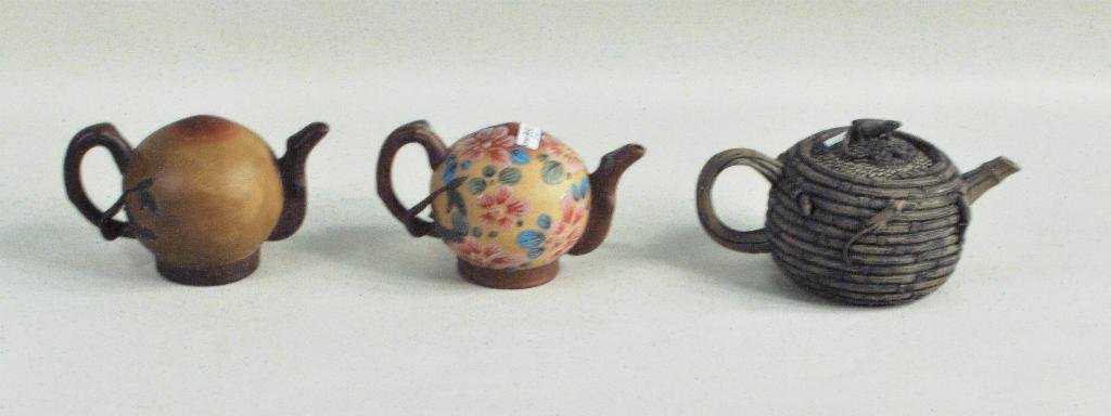 Three Chinese Pottery Teapots: Three Chinese pottery teapots, 19th/20th C., comprising two Xixing puzzle teapots, both signed on base and a basket form teapot with mice decoration. Largest: 4 1/2" high, 8 1/4" wide; 4" high, 6 1/2"