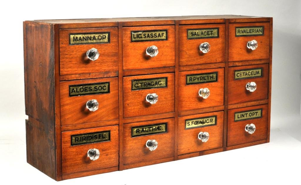 Hanging 12 Drawer Wood Apothecary Chest: Hanging twelve drawer wood apothecary chest, 19th C., with hand painted and gilded glass labels and glass pulls. 17 1/2" high, 32 1/4" wide.