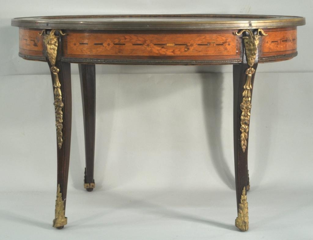 French Marquetry & Bronze Oval CoffeeTable: French marquetry and bronze mounted oval coffee table, 19th/20th C., with inset marble top, floral marquetry border and apron on bronze mounted legs, ending in hoof feet. 20 1/4" high, 29 1/4" wide, 2