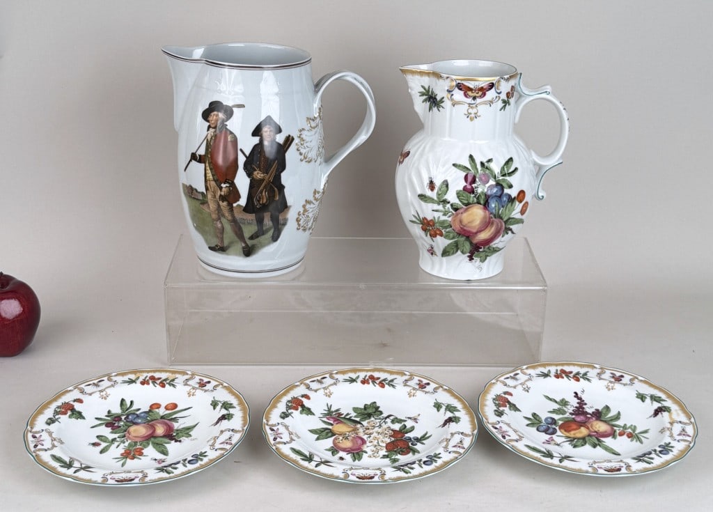 Five Pieces Mottahedeh Porcelain Accessories: with Colonial Williamsburg Restoration Duke of Gloucester pitcher and three plates and V. Green the Society of Goffers at Blackheath. Larger pitcher: 9 1/4" high, 9" wide, 6 1/2" diameter. Light age a