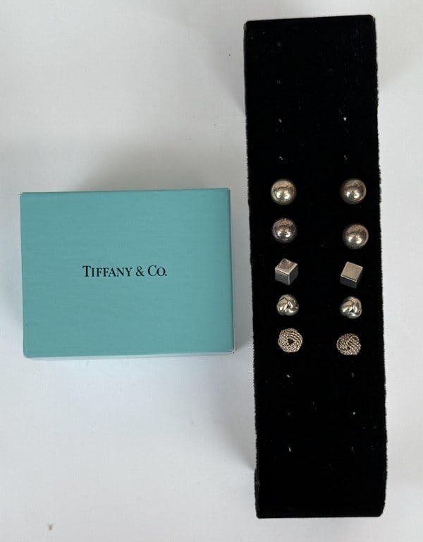 Five Pair Tiffany Sterling Earrings: comprising twist knot, hardball, cube form and ball studs. Weight: .805 OZT. Age and use wear, some bent posts, some missing backings. *No credit card payments will be accepted for silver, gold, or je