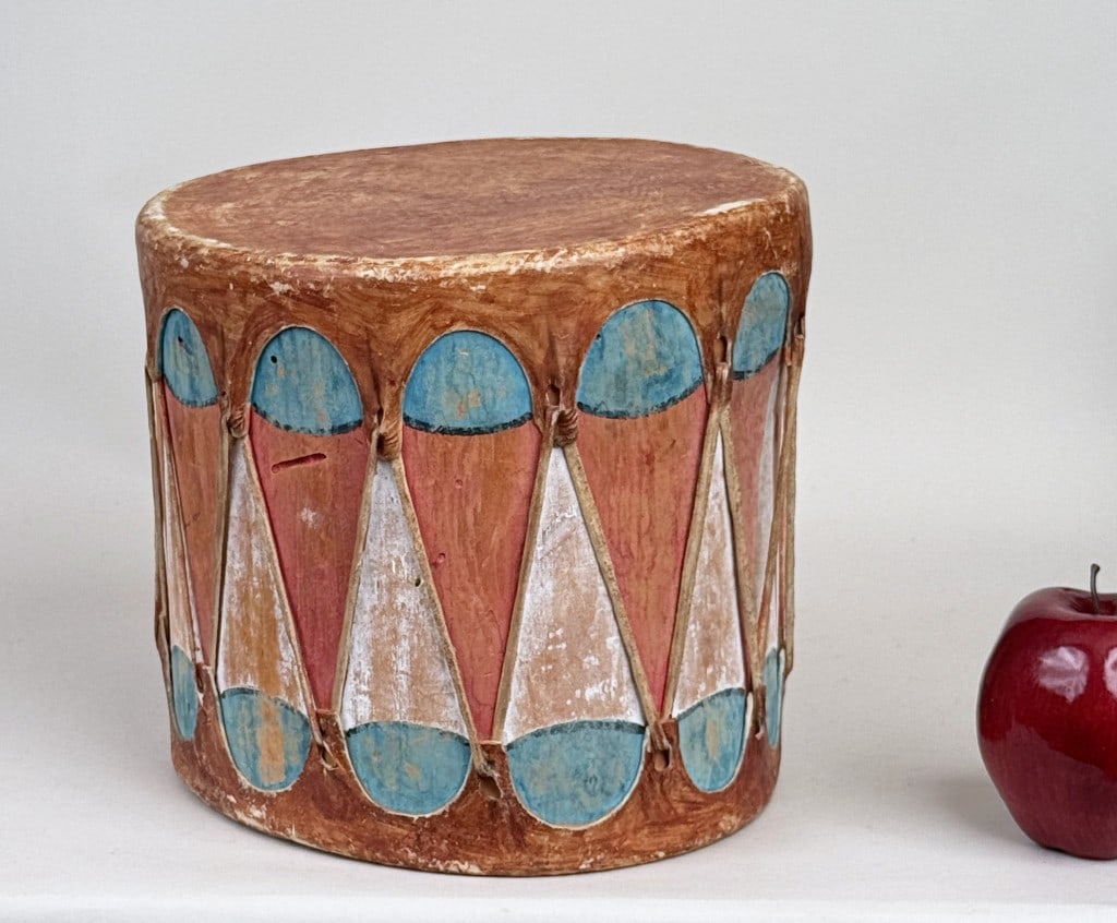 Small Native American Hide Drum: likely Conchiti Pueblo; with painted turquoise and coral colors. 8" high, 9 1/8" wide, 8 3/8" deep. Insect damage, wear to leather.