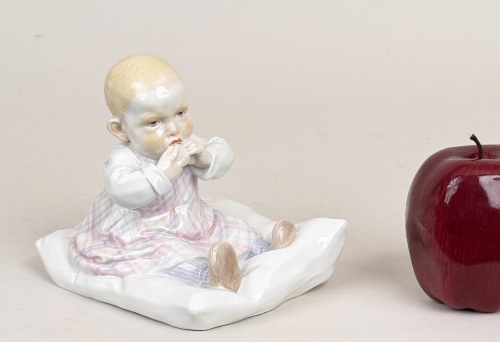 Meissen Hentschel Seated Child Porcelain Figure: Konrad Hentschel (1872-1907) for Meissen, porcelain model of a seated teething young girl on a cushion, blue crossed swords mark and numbered underside. 5 1/8" high, 4 1/2" wide, 5 1/2" deep.