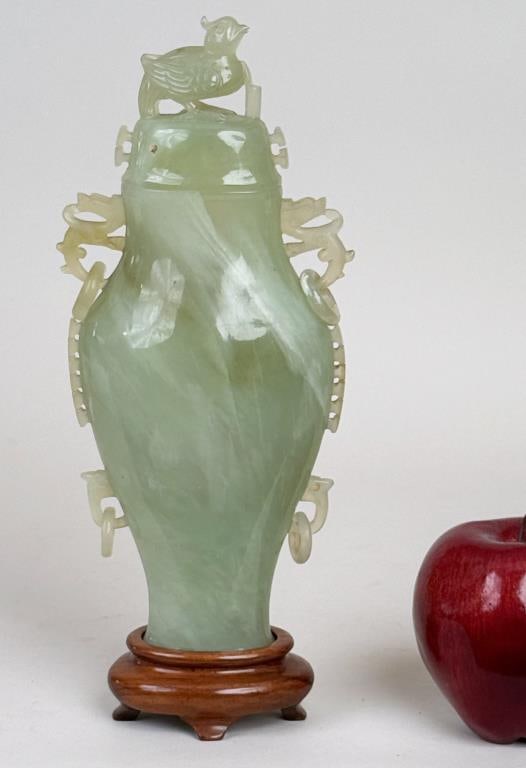 Chinese Carved Hardstone Lidded Urn/Jar: pale green stone, baluster form with bird finial. Without base: 10" high, 4 3/4" wide, 1 5/8" deep. Natural cracks.