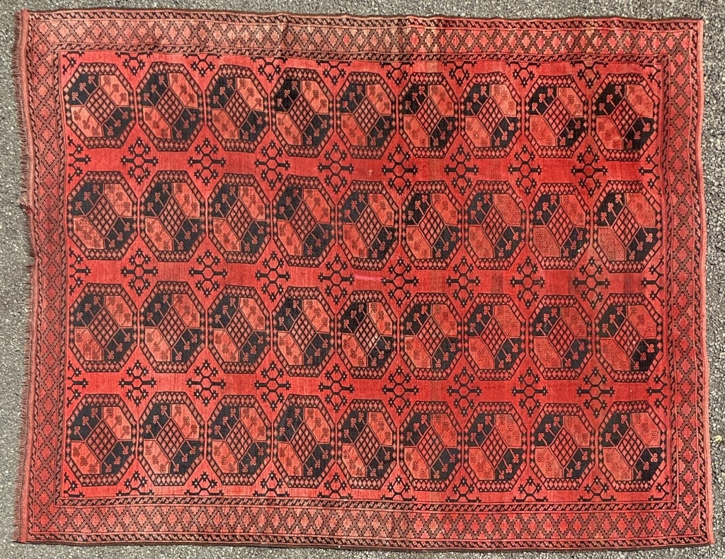 Afghan Medallion Carpet: 12' 9" long, 9' 11 1/2" wide. Fading, areas of low pile. All rugs sold as is.