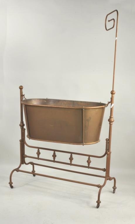 French Victorian Brass & Copper Cradle: French Victorian copper and brass rocking crib, 19th century, on copper tubular support and stretchers with decorative turned brass elements, on casters. 73" high, 41 3/4" wide, 19 1/2" deep. Conditio