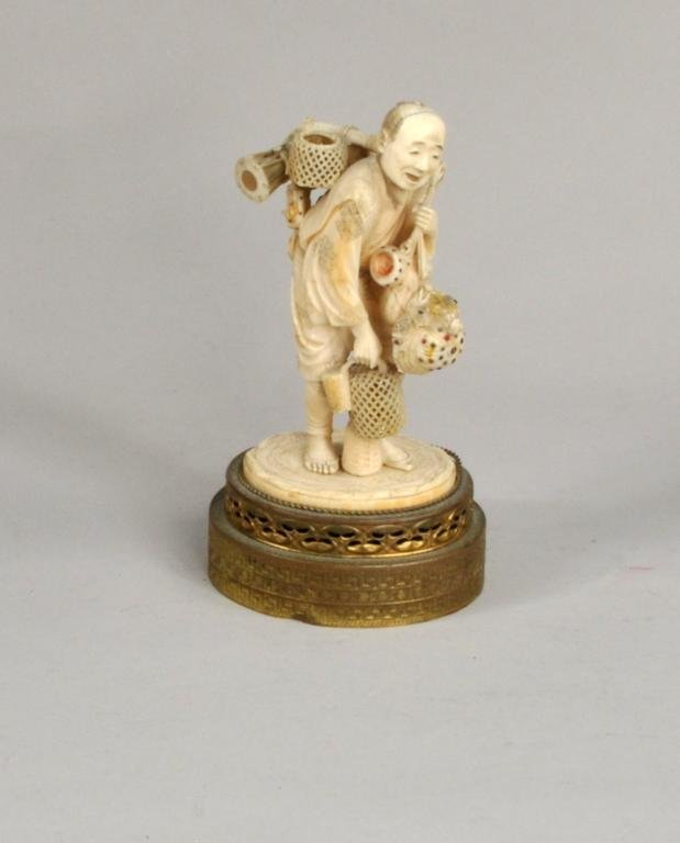 Japanese Carved and Inlaid Ivory Figure: Japanese carved and inlaid ivory figure of a basket seller, 19th century, with mother of pearl and hard stone inlay. Figure: 5 1/2" high, 3 1/2" wide. Condition: losses to hat and one item suspended f