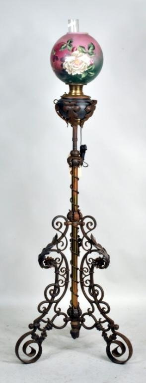 Large Bradley & Hubbard Organ Lamp/Shade: Bradley & Hubbard wrought iron and brass organ lamp, 19th century, electrified with scrolled floral base, reservoir marked B&H, with a hand painted floral shade. 64" high, 22" wide. Condition: paint w