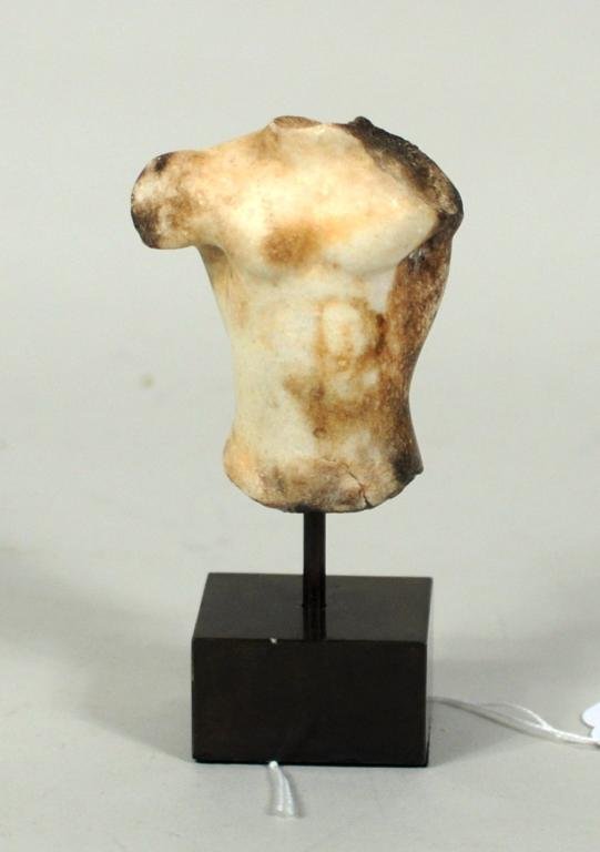 Roman Marble Sculpture Fragment: Roman marble sculpture fragment consisting of upper torso, mounted on display stand. Fragment: 3 1/4" high, 2 3/4" wide. Condition: crack to lower edge of body.
