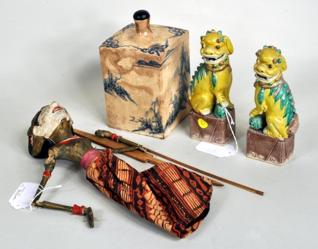 Four Asian Items: Four Asian items, 19th/20th century, comprising a possibly Chinese porcelain square bottle with hand painted scenes, a pair of Fu lions and a Balinese shadow puppet. 8" high, 3 1/4" wide to 19" long, 