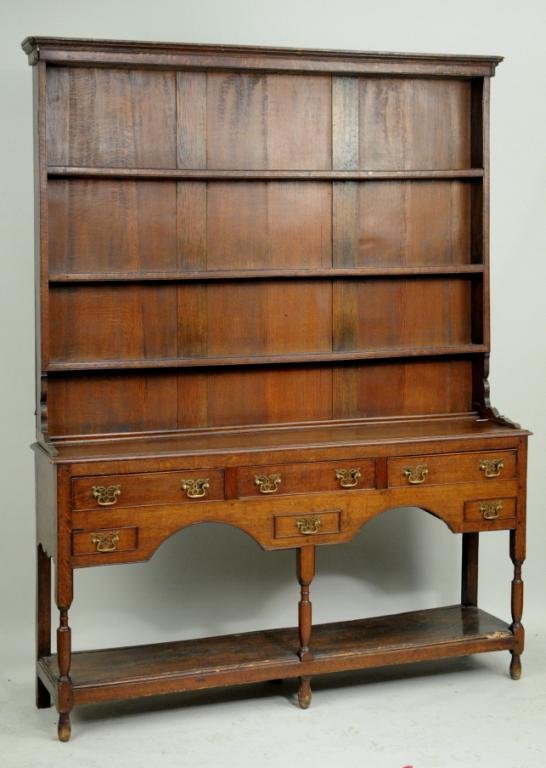 English Oak Two Part Welsh Dresser: English oak two part Welsh dresser, 18th/19th century, top with molded cornice over three plate shelves; base with three long drawers over three short drawers (faux middle drawer) on turned front legs