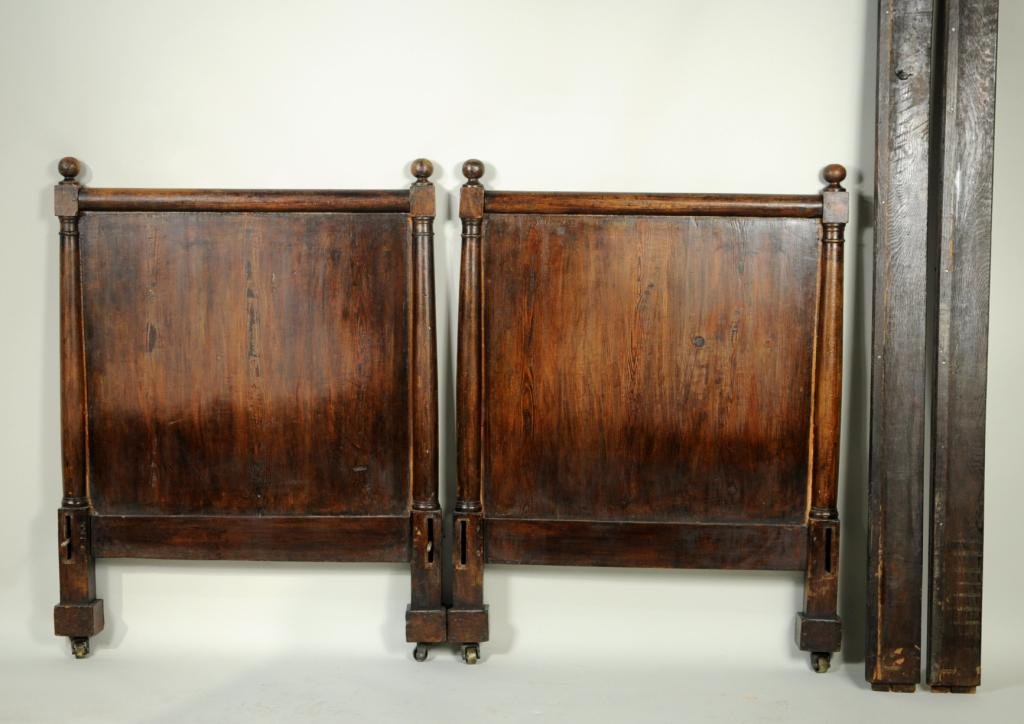 Empire Mixed Woods Daybed, 19th C.: Empire mixed woods daybed, 19th century, with column form sides flanking solid panels on casters. 44" high, 32 3/4" wide, 76 1/2" long. Condition: age cracks, finish wear, loss, chips.