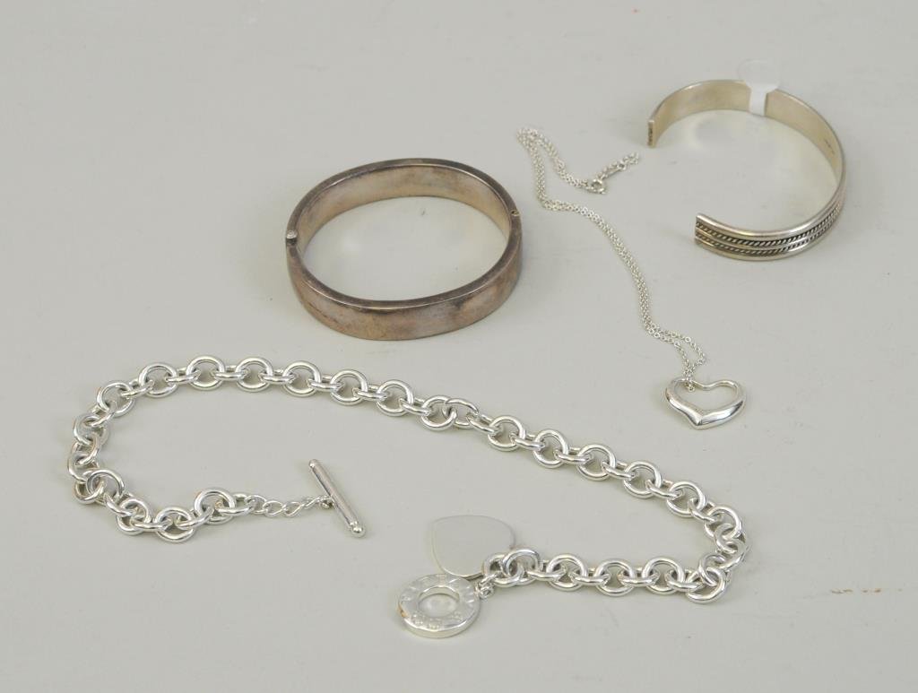 Four Sterling Silver Items,Tiffany & Co. & Tahe: Four sterling silver items, Tiffany & Co. and Tahe, comprising : a heart link necklace, a bangle, and an Elsa Peretti heart necklace, all marked "Tiffany & Co." together with a Tahe sterling bracelet.