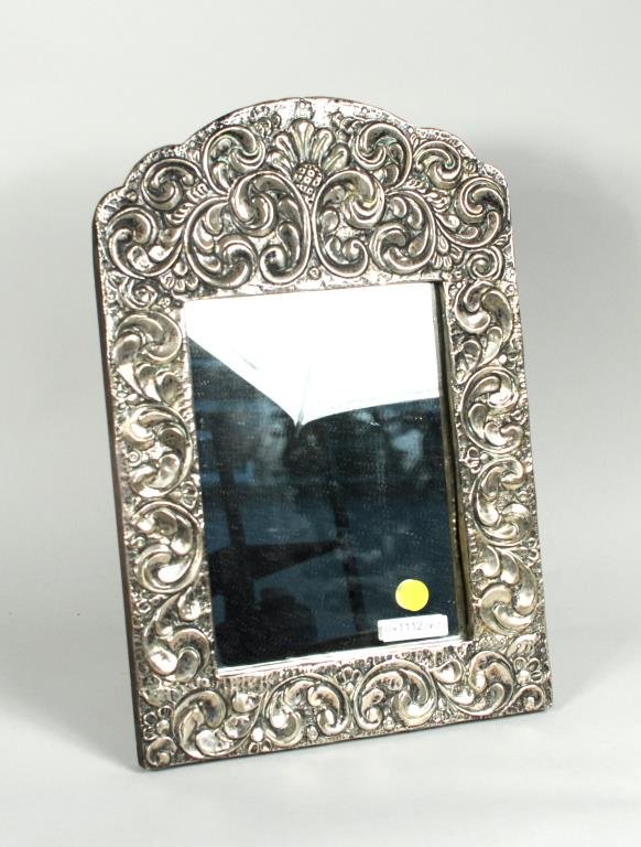South American Silver Repousse Dressing Mirror: South American silver repousse dressing mirror, 20th century, 16" high, 10 3/4" wide. Condition: appears to be silver, not hallmarked; stand support needs reattaching.