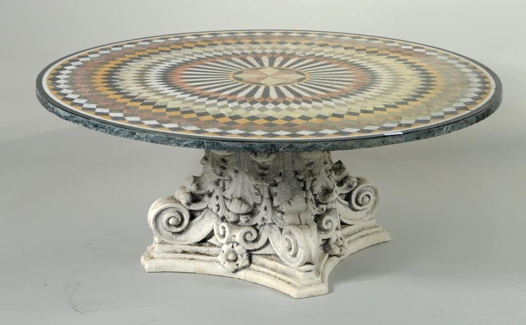 Large Pietra Dura Style Round Marble Top Table: Large inlaid circular marble top table, with geometric hardstone inlaid design, set on a Corinthian carved plaster base, probably Indian, 20th century. 18 1/2" high, 48" diameter.