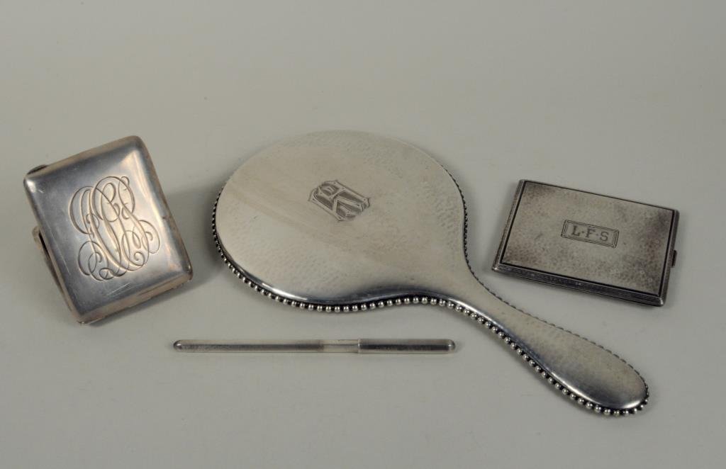 Four Personal Silver Articles: Four personal silver articles, 19th/20th century, comprising a Black Starr & Frost travel clock, Webster Co. cigarette case, an 830 silver handled mirror, all monogrammed, and a silver clad pen marked