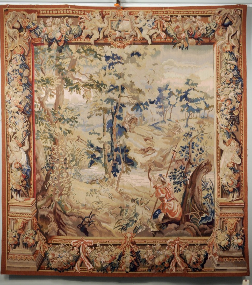 Aubusson Style Wool Tapestry: Aubusson style wood tapestry, 20th century, with central hunt scene of fox, hound and rider, enclosed by wide border of putti, fruit and foliate designs. 86 1/2" high, 79" wide.