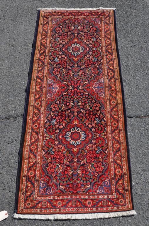 Persian Runner: Persian runner, 20th century, having two central medallions on a navy floral ground, red floral primary border. 84 1/2" long, 28 1/2" wide. All rugs sold "as is".