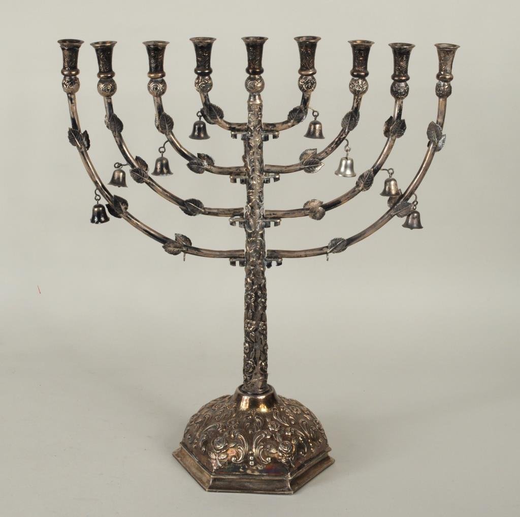 Polish Repousse .800 Silver Menorah: Polish repousse .800 silver menorah, rose and leaf decoration with bell suspensions. Provenance: purchased at Mariah Gallery, NYC for $6,000. 16" high, 13 3/4" wide. Weight: 22.435 OZT. Condition: mis