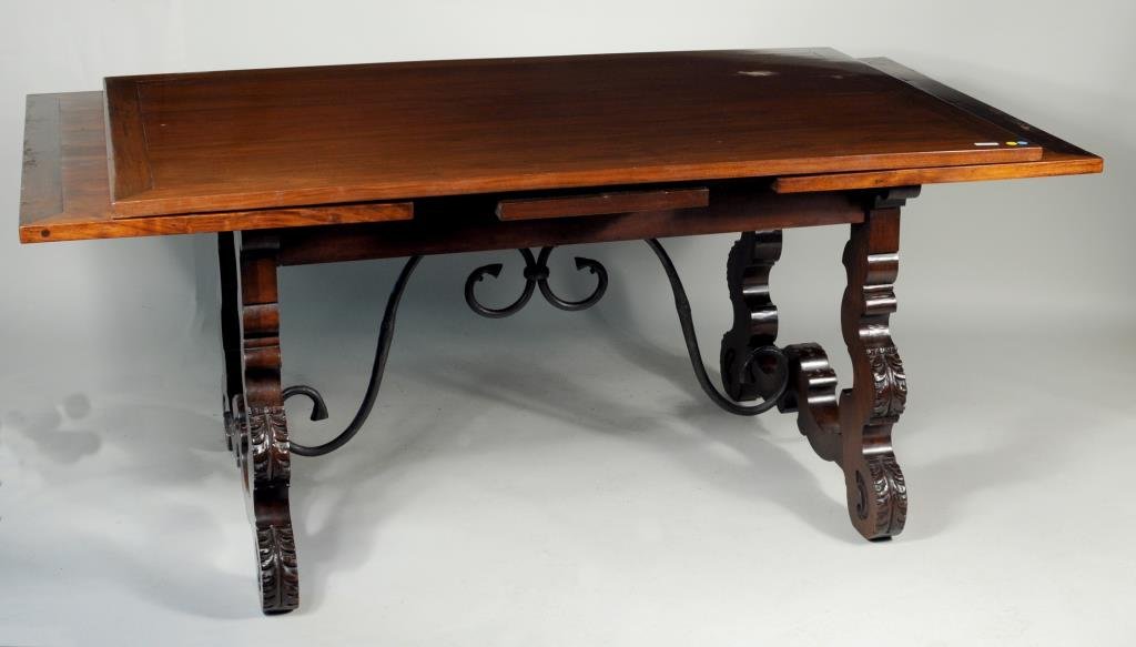 Spanish Baroque Style Dining Table: Spanish Baroque style dining table with cutout legs and wrought iron stretcher. 31 1/4" high,,42" wide, 65 3/4" long (closed) 117" long (open). Condition: extensions with cracks,with marring to top.