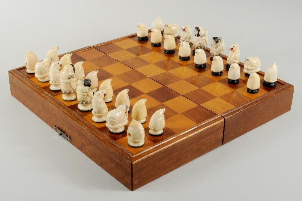 Inuit Scrimshaw Marine Ivory Chess Set: Inuit scrimshaw marine ivory chess set, figures depicting Inuit couple, bears, walrus, seals and igloos. 1 1/4" high, 3/4" wide to 2" high, 1" wide.