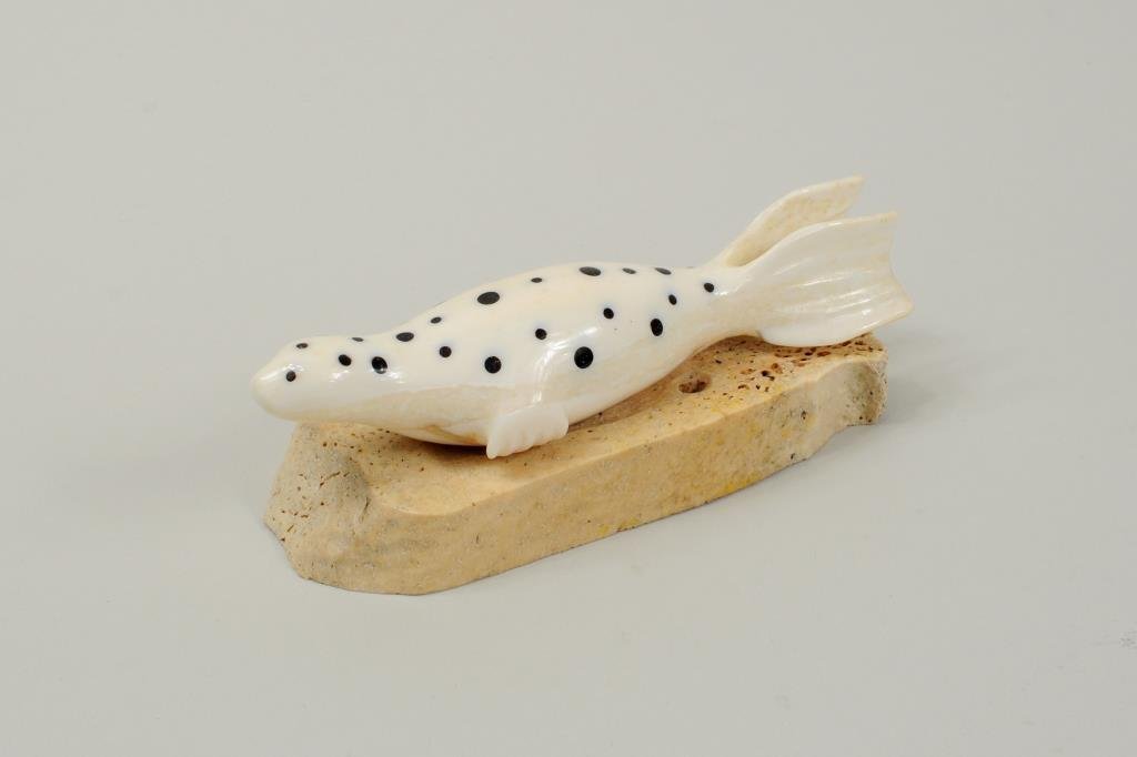 Inuit Carved & Baleen Inlaid Marine Ivory Seal: Inuit carved and baleen inlaid marine ivory leopard seal on whalebone base, signed on base "Byron Kaningok". 1 1/2" high, 4 1/2" long.