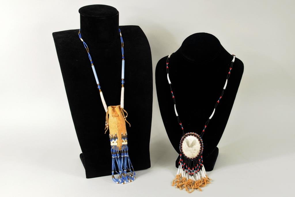 Two Inuit Beaded Necklaces: Two Inuit beaded necklaces comprising a scrimshaw necklace and a quill pouch necklace. Scrimshaw pendant 2 1/4" high, 2" long. Pouch 3 3/4" high, 1 1/2" wide, approximate length 18" long.
