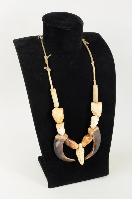 Inuit Carved Walrus Ivory/Bear Claw Necklace: Inuit carved walrus ivory, bone and grizzly bear claw necklace, three beads with carved faces, central pendant signed "Luke". 1 1/2" wide, 13" hang length.