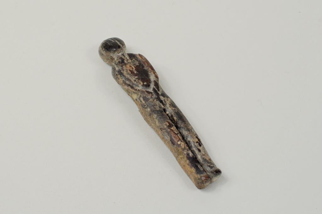 Inuit Carved Fossilized Doll: Inuit carved fossilized doll. 4 1/8" long, 7/8" wide.