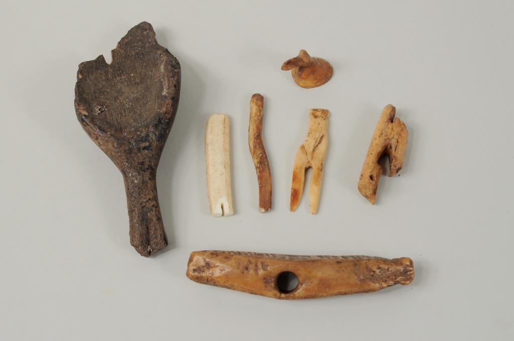 Group of Inuit Carved Fossilized Tools: Group of Inuit carved fossilized tools including a seal oil lamp scoop, a rope holder and other items. 1" long, 7/8" wide to 4 3/4" long, 2" wide.