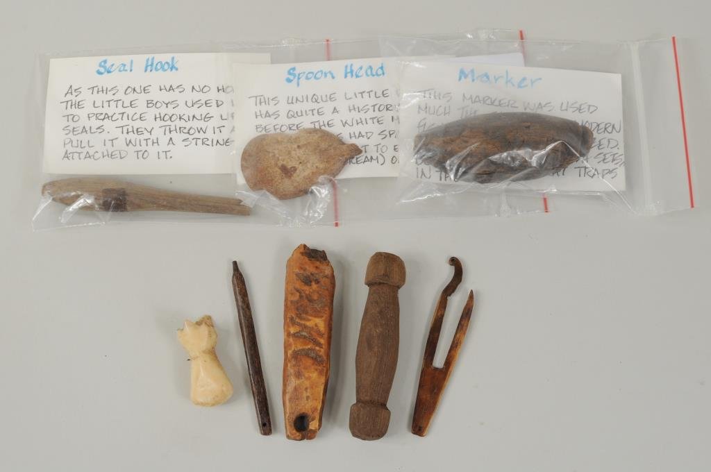 Eight Inuit Carved Fossilized & Wood Tools: Eight Inuit carved fossilized and wood tools including a hook with incised decoration, a float plug and other items. 1 1/2" high, 5/8" wide to 3/4" wide, 3" long.