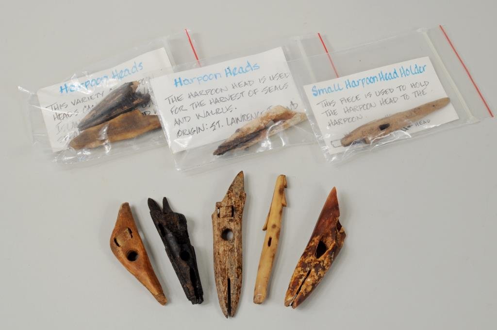 Nine Inuit Carved Fossilized Hunting Items: Nine Inuit carved fossilized hunting items including harpoon heads and a harpoon head holder. 3/8" wide, 3 1/4" long to 3/4" wide, 3 1/2" long.