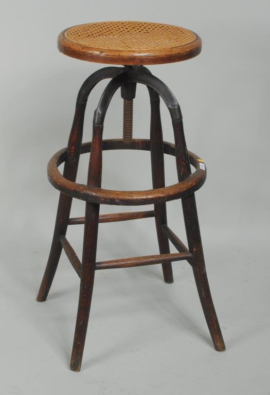 Thonet Style Adjustable Bentwood & Iron High Stool: Thonet style adjustable bentwood and iron high stool with caned seat. 31" high, 15 3/4" wide. Condition: finish wear, losses, rust, paint residue, break to cane seat.