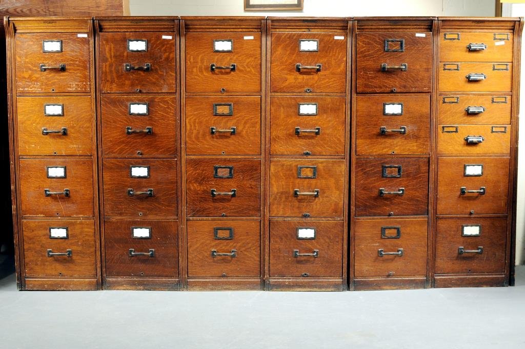 Six Section Oak Four Drawer File Cabinets: Six section oak four drawer file cabinets manufactured by Yawman and Erbe Manufacturing Co., Rochester, NY. Each unit 53" high, 15 3/4" wide. Condition: use, finish wear, loss, stains, scratches.